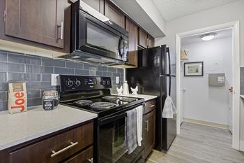 A kitchen with black appliances and brown cabinets